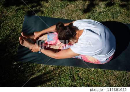 Woman practicing yoga outdoors on a sunny day Woman practicing yoga outdoors on a sunny day 115861683