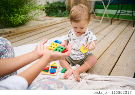 Toddler playing with educational toy blocks outdoors 115862017