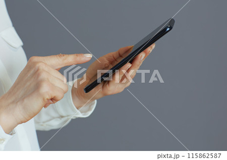 Stylish woman employee using phone isolated on grey Stylish woman employee using phone isolated on grey 115862587