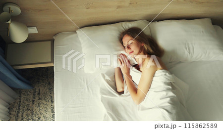 Woman sleeping lying in bed on white soft comfortable pillow in bedroom at home 115862589