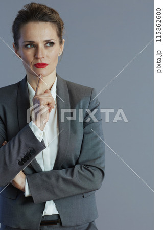pensive elegant 40 years old woman worker isolated on gray pensive elegant 40 years old woman worker isolated on gray 115862600