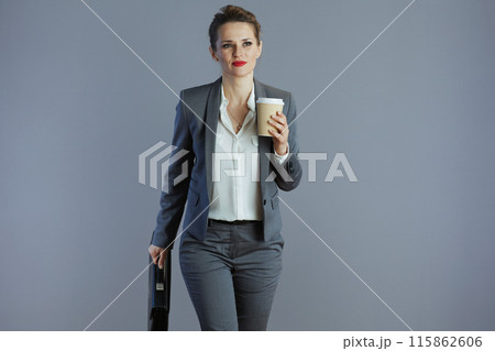 pensive 40 years old business owner woman walking against gray pensive 40 years old business owner woman walking against gray 115862606