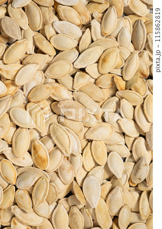 Close-up of unpeeled pumpkin seeds from above. Close-up of unpeeled pumpkin seeds from above. 115862819