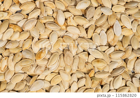 Close-up of unpeeled pumpkin seeds from above. Close-up of unpeeled pumpkin seeds from above. 115862820