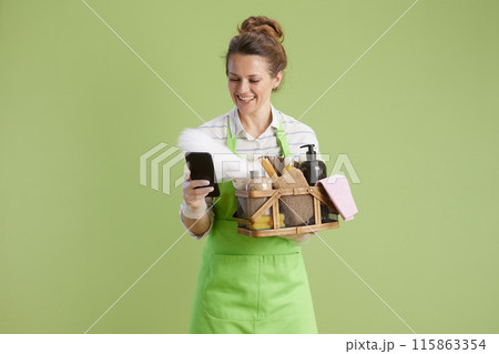 happy 40 years old woman using smartphone on green 115863354