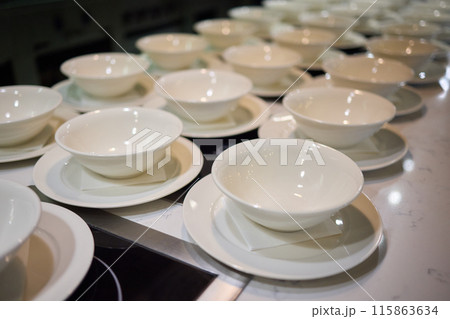 Neatly stacked white coffee cups for elegant events or catering, making a stylish presentation Neatly stacked white coffee cups for elegant events or catering, making a stylish presentation 115863634