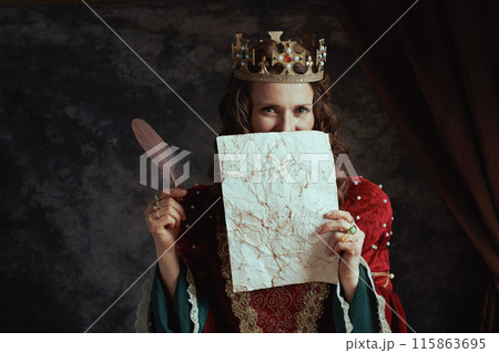 medieval queen in red dress with parchment and crown 115863695