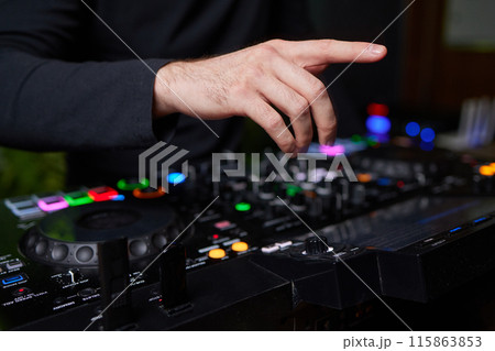 control DJ for mixing music with blurred people dancing at party in nightclub. control DJ for mixing music with blurred people dancing at party in nightclub. 115863853
