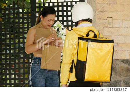 Woman Checking Her Parcel Outdoors 115863887