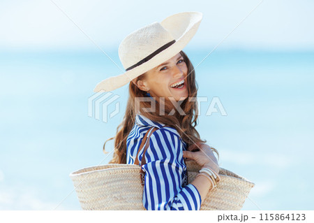 happy modern woman on seashore with straw bag happy modern woman on seashore with straw bag 115864123