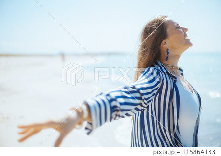 smiling stylish woman on beach rejoicing smiling stylish woman on beach rejoicing 115864133