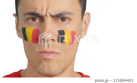 Serious man with a belgian flag painted on the face 115864401