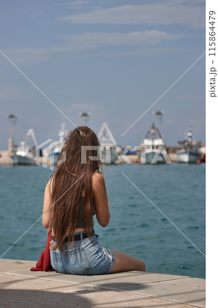 Woman by the seaside from the back 115864479