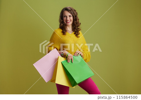 smiling trendy 40 years old woman isolated on green background smiling trendy 40 years old woman isolated on green background 115864500