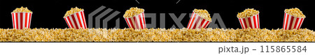 Scattered popcorn from paper striped bucket isolated on black background Scattered popcorn from paper striped bucket isolated on black background 115865584