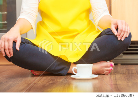 Woman with cup of coffee in kitchen. 115866397