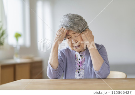 頭を抱える80代の女性 115866427