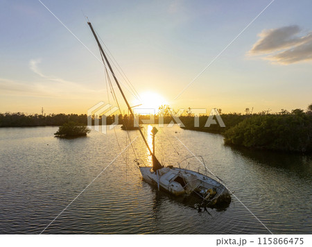 Aerial view of sunken sailboat on shallow bay waters after hurricane in Manasota, Florida Aerial view of sunken sailboat on shallow bay waters after hurricane in Manasota, Florida 115866475