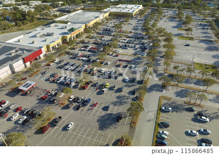 Top view of many cars parked on a parking lot in front of a shopping mall in Florida. Concept of urban transportation Top view of many cars parked on a parking lot in front of a shopping mall in Florida. Concept of urban transportation 115866485