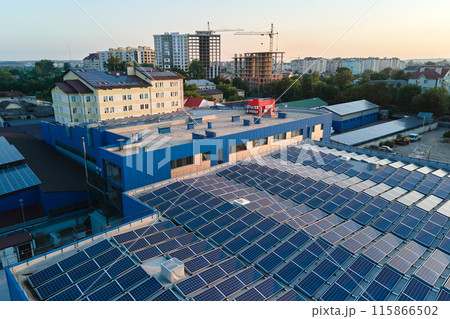 Aerial view of blue photovoltaic solar panels mounted on industrial building roof for producing green ecological electricity. Production of sustainable energy concept Aerial view of blue photovoltaic solar panels mounted on industrial building roof for producing green ecological electricity. Production of sustainable energy concept 115866502