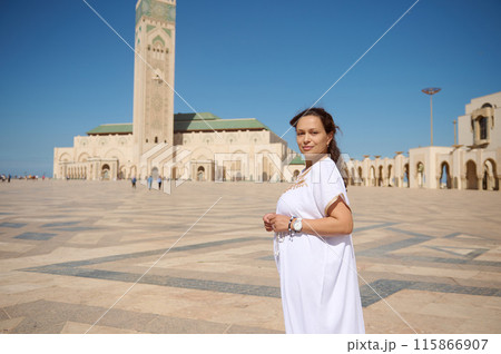 Woman standing in front of Hassan II Mosque in Casablanca on a sunny day 115866907
