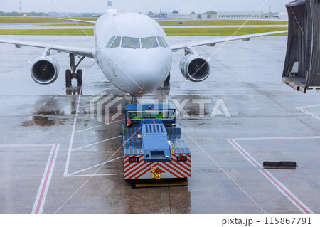 During rain, preparation for departure airplane is rolled out from terminal gate ready for takeoff During rain, preparation for departure airplane is rolled out from terminal gate ready for takeoff 115867791