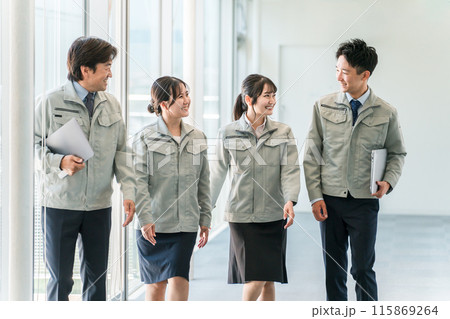 オフィスの廊下を歩く作業服姿のビジネスマン男女（上司・部下・チーム・同僚） 115869264