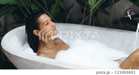 Luxury bath african woman relaxing in hotel spa bathtub or home bathroom for total relaxation 115869891