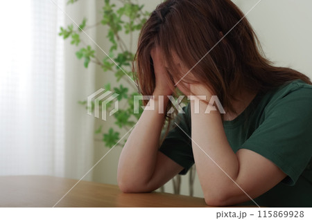 頭を抱えている40代の女性 頭を抱えている40代の女性 115869928