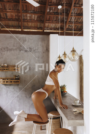 Sexy Woman in Minimal Attire Enjoying Morning in Stylish Kitchen 115872180