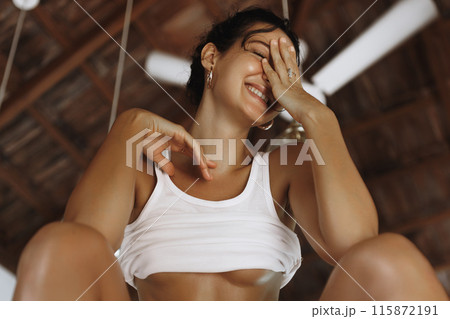 Playful Woman in Minimal Attire Laughing at Home 115872191