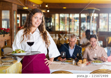 Waiter standing with serving tray, recommending dishes in restaurant 115872499
