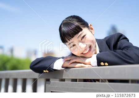 屋上の手すりに寄りかかる女子高生 115872673