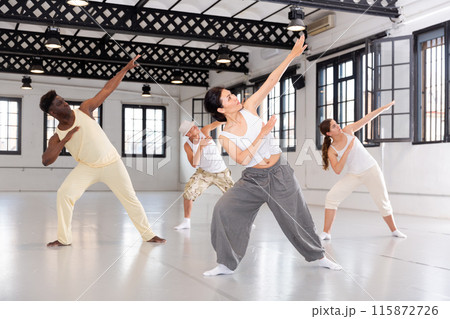 Group of young people learning modern dance movements Group of young people learning modern dance movements 115872726