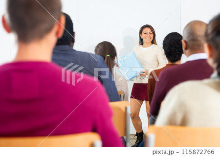 Businesswoman advertises product in front of an audience 115872766