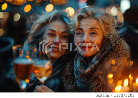 Two cheerful senior women share a cheerful toast with wine glasses amid the warm glow of evening city lights 115873203