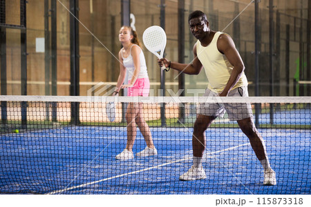 African american man playing paddle tennis on padel court 115873318