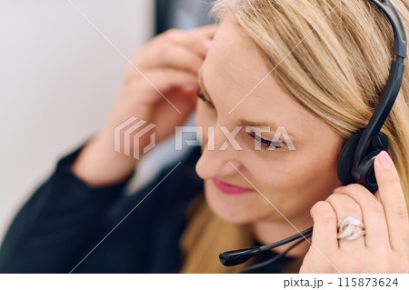Friendly Call Center Agent Answering Incoming Calls with Headset Providing Remote Customer Service. 115873624