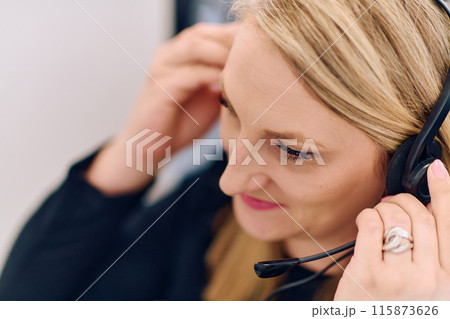 Friendly Call Center Agent Answering Incoming Calls with Headset Providing Remote Customer Service. 115873626