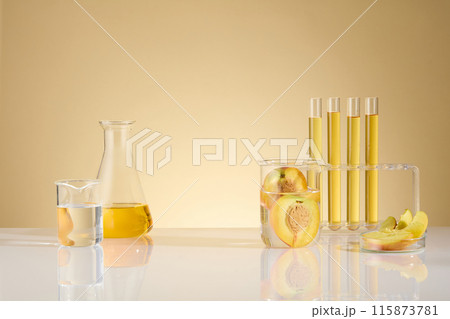 Photo for advertising product extracted from organic peach fruit, the lab table contain some experiment tools like test tube, beaker, petri dish and yellow fluid erlenmeyer, product displaying space 115873781