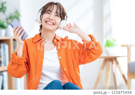 ヘッドホンで音楽を聴く若い女性 115875459