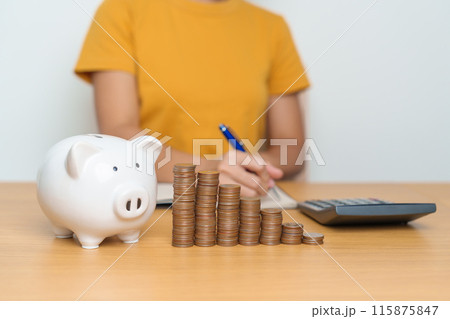 Money Saving for Future Plan, Retirement fund, Pension, Investment, Wealth Business and Financial concepts. Woman Counting and calculate money with coins stack with piggy bank for deposit 115875847