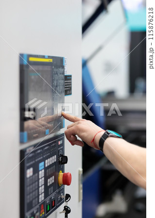 CNC machine operator working at the control panel 115876218
