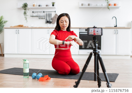 Sporty woman explains smart watch features during online fitness class Sporty woman explains smart watch features during online fitness class 115876756