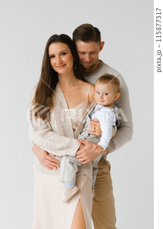 Portrait of a happy young family with a one-year-old son in their arms 115877317