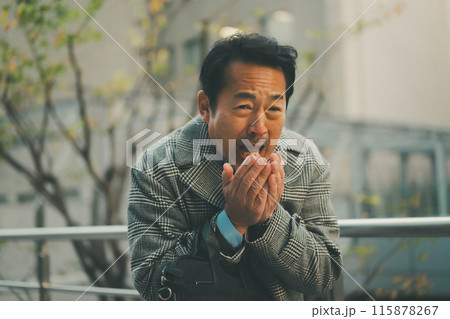 寒さで手に息を吹きかける50代サラリーマン 115878267