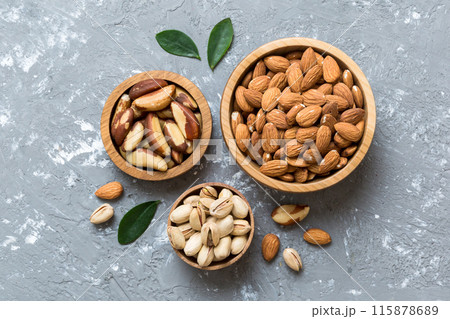mixed nuts in wooden bowl. Mix of various nuts on colored background. pistachios, cashews, walnuts, hazelnuts, peanuts and brazil nuts mixed nuts in wooden bowl. Mix of various nuts on colored background. pistachios, cashews, walnuts, hazelnuts, peanuts and brazil nuts 115878689