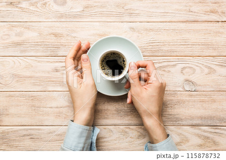 Minimalistic style woman hand holding a cup of coffee on Colored background. Flat lay, top view cappuccino cup. Empty place for text, copy space. Coffee addiction. Top view, flat lay Minimalistic style woman hand holding a cup of coffee on Colored background. Flat lay, top view cappuccino cup. Empty place for text, copy space. Coffee addiction. Top view, flat lay 115878732