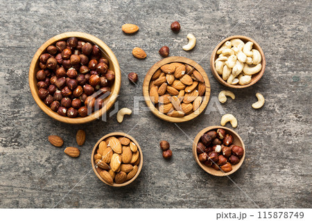 Assortment of nuts in wooden bowl on colored table. Cashew, hazelnuts, walnuts, almonds. Mix of nuts Top view with copy space 115878749