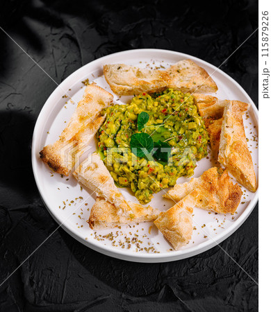 Avocado chickpea salad with pita triangles 115879226
